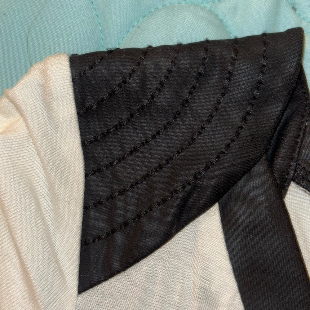 White t-shirt with black neckline and shoulder details on cap sleeves.